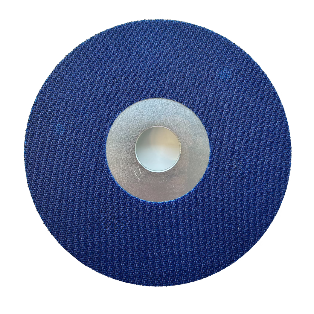 PALLMANN_Dummy_Satellitenscheibe_Klett_180mm High-resolution top-down image of a circular blue abrasive disc with a textured fabric surface and a central metallic hub. The disc is evenly round with a fine woven grit pattern visible across the blue surface; a silver metal ring surrounds the central round bore which is recessed slightly. The object is photographed on a clean white background, showing clear edges and uniform lighting that highlights the texture and material of the sanding/grinding disc intended for rotary tools and angle grinders.