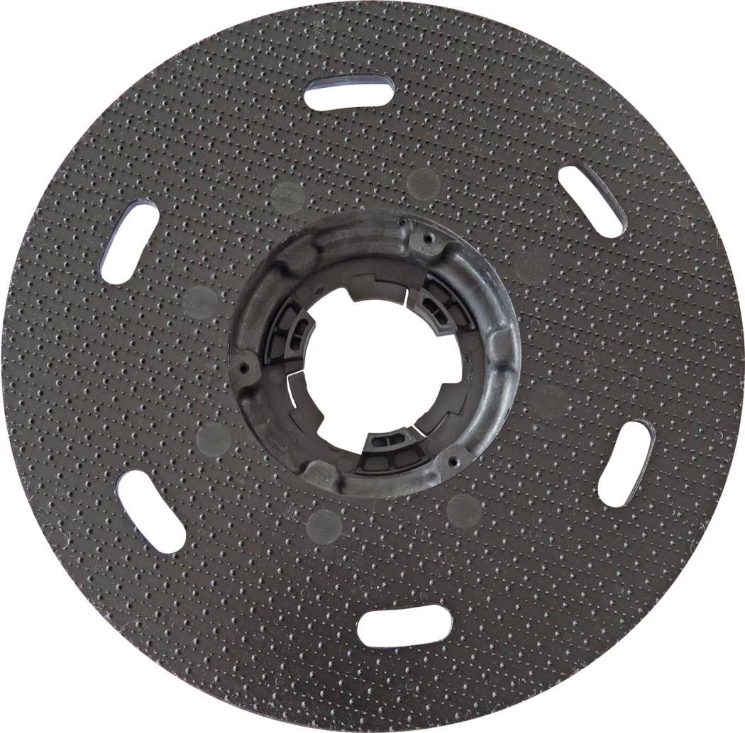 PALLMANN_dummy_PALLMANN SPIDER pad disc with coupling_msl_2017-02 Placa de soporte circular de plástico negro con superficie texturizada por pequeños puntos y un cubo de bloqueo central; varias ranuras ovaladas alargadas están distribuidas uniformemente cerca del borde exterior; una abertura central redonda contiene elementos de retención moldeados para acoplarla a una herramienta; se utiliza como base para discos de lijado o pulido; la superficie presenta puntos elevados uniformes para mejorar el agarre; se aprecian leves signos de uso; fotografiada sobre fondo blanco.